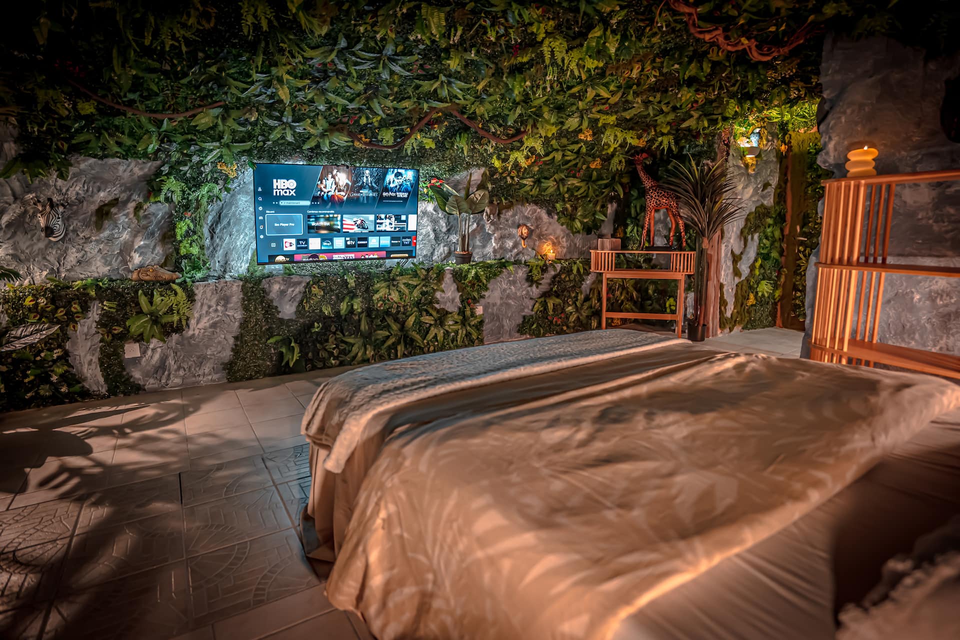 Vue d'ensemble de la love room Junglecavern avec spa privatif et coin détente